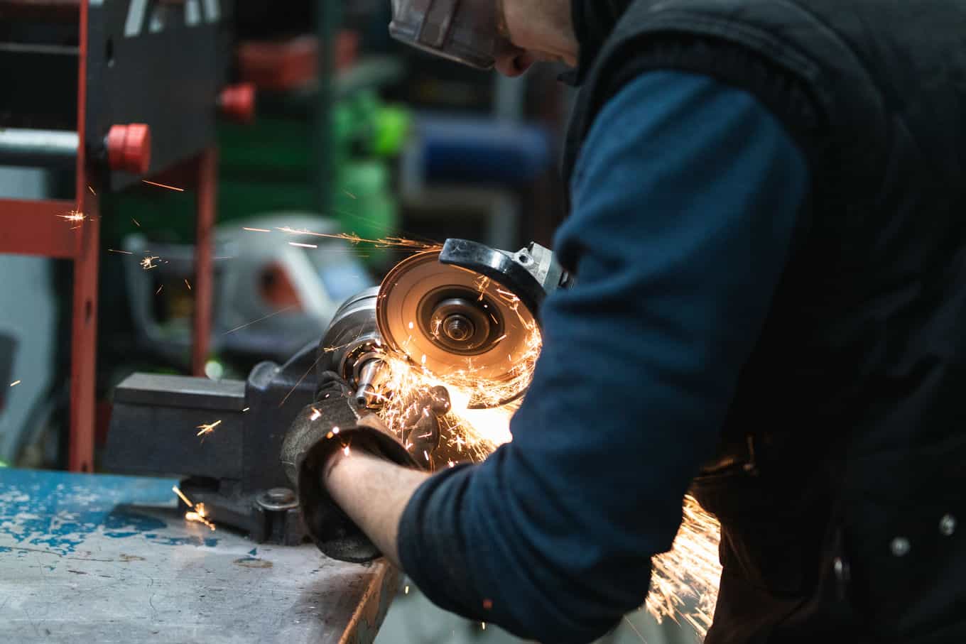 un-reparador-atento-cortando-metal-con-una-fresadora-electrica-en-el-taller