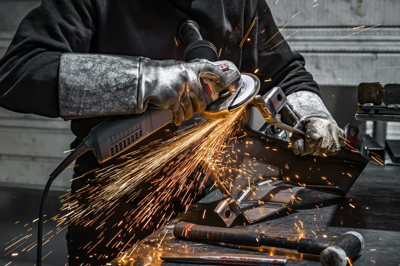 vista-del-trabajador-moliendo-una-pieza-de-metal